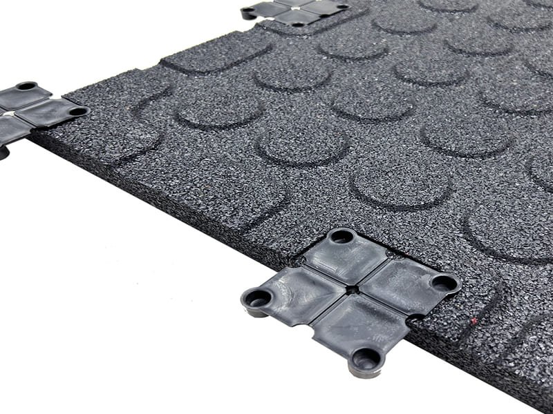 Suelo del gimnasio con pasarelas de seguridad y zonas funcionales claramente marcadas en diferentes colores.